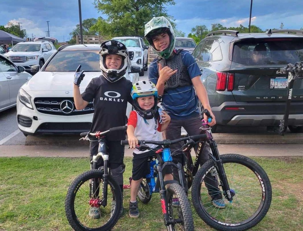 Young riders geared up with mountain bikes at a Bentonville trailhead